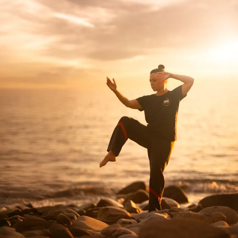 Sifu Tanja Fenz in einer Taiji Stellung am Meer auf Madeira